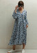 Coral color dress in a flower pattern with voluminous sleeves